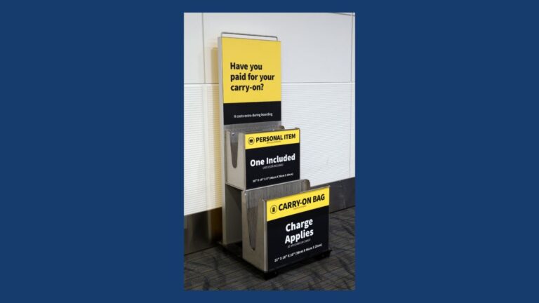 Airport baggage sizers showing personal item and carry-on bag fees
